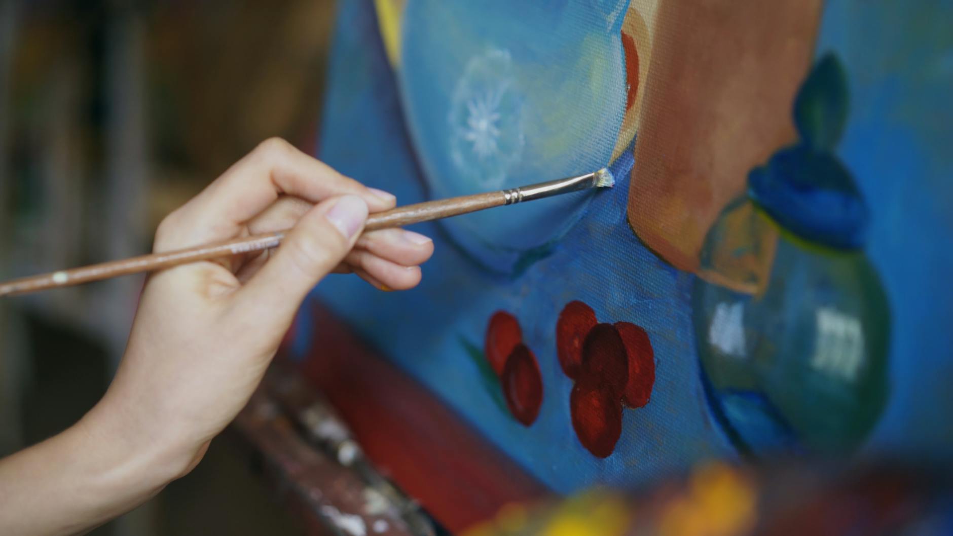 close up of hand painting abstract art on canvas